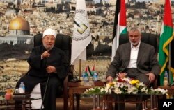 Ulama berpengaruh Yusuf al-Qaradawi, kiri, berbicara saat Perdana Menteri Hamas Gaza Ismail Haniyeh mendengarkan, selama pertemuan mereka di Kota Gaza, Kamis, 9 Mei 2013. (Foto: AP)