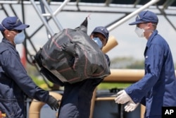 امریکہ کے ساحلی علاقے میامی سے کوسٹل گارڈز نے اسمگلروں سے 8 ٹن کوکین برآمد کی۔ کوکین کے بیگ کشتی سے اتارے جا رہے ہیں۔ فائل فوٹو