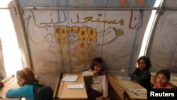 FILE - Children attend a class inside a makeshift school in the Bab al-Salam refugee camp in Azaz, Syria, Oct. 27, 2014.