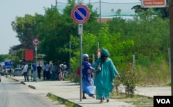 African women in traditional dress running to catch a bus in Castel Volturno. The decaying coastal resort is home to an estimated 20,000 African migrants. (Photo: Jamie Dettmer for VOA)