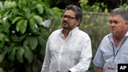 Ivan Marquez, chief negotiator for the Revolutionary Armed Forces of Colombia, or FARC (l) accompanied by a security officer, arrives for a news conference at the close of the 19th round of peace talks with Colombia's government in Havana, Cuba, Feb. 13, 
