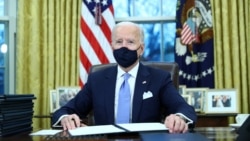 Tổng thống Mỹ Joe Biden kí các sắc lệnh hành pháp trong Phòng Bầu dục của Nhà Trắng ở Washington, sau khi ông nhậm chức tổng thống thứ 46 của Hoa Kỳ, ngày 20 tháng 1, 2021.