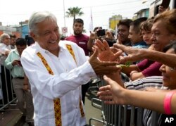 FILE - Presidential hopeful and two-time candidate Andres Manuel Lopez Obrador greets supporters in Nezahualcoyotl, Mexico state, May 28, 2017.