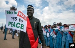 South Sudanese people hold signs as they await the arrival back in the country of South Sudan's President Salva Kiir, at the airport in Juba, South Sudan, June 22, 2018.