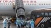 接载港人从武汉撤离的包机3月4日下午返抵香港国际机场。机上港人离开飞机后随即在身着保护衣的工作人员指示下登上专车前往隔离营。（香港政府新闻处）
