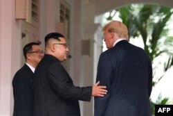 김정은 북한 국무위원장이 도널드 트럼프 대통령과 함께 단독회담장으로 이동하며 트럼프 대통령의 팔에 손을 얹었다.