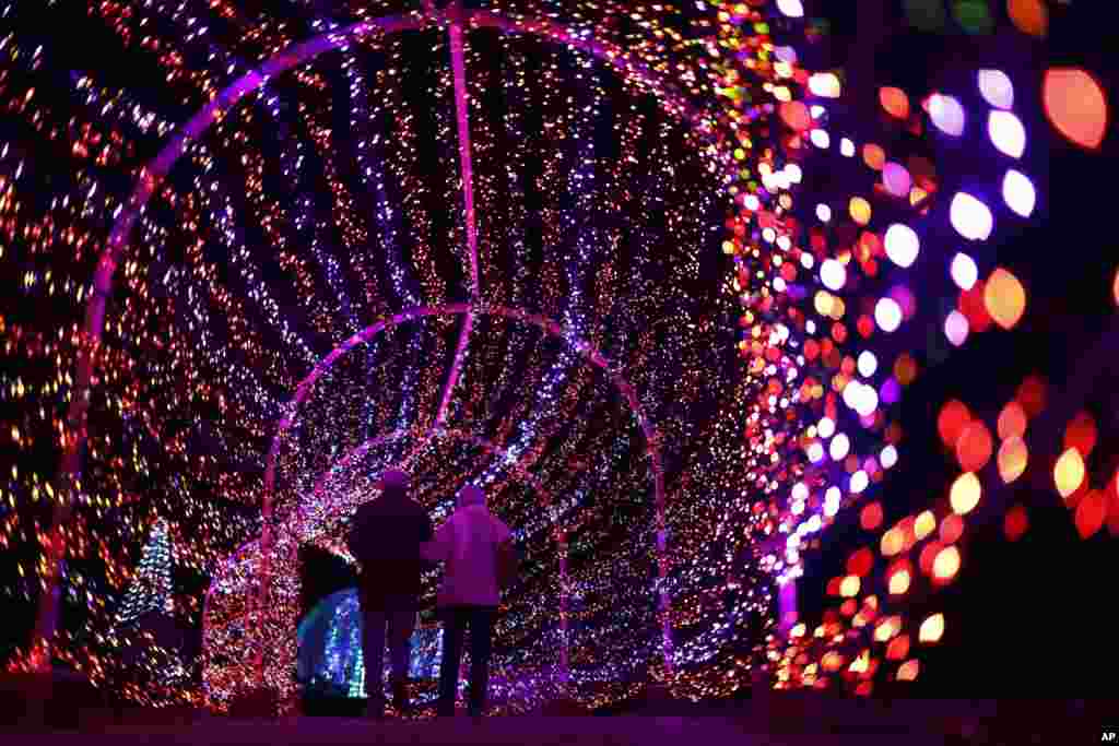 A couple walks through a tunnel of light during the annual Garden Glow at Missouri Botanical Garden, Dec. 3, 2019, in St. Louis.
