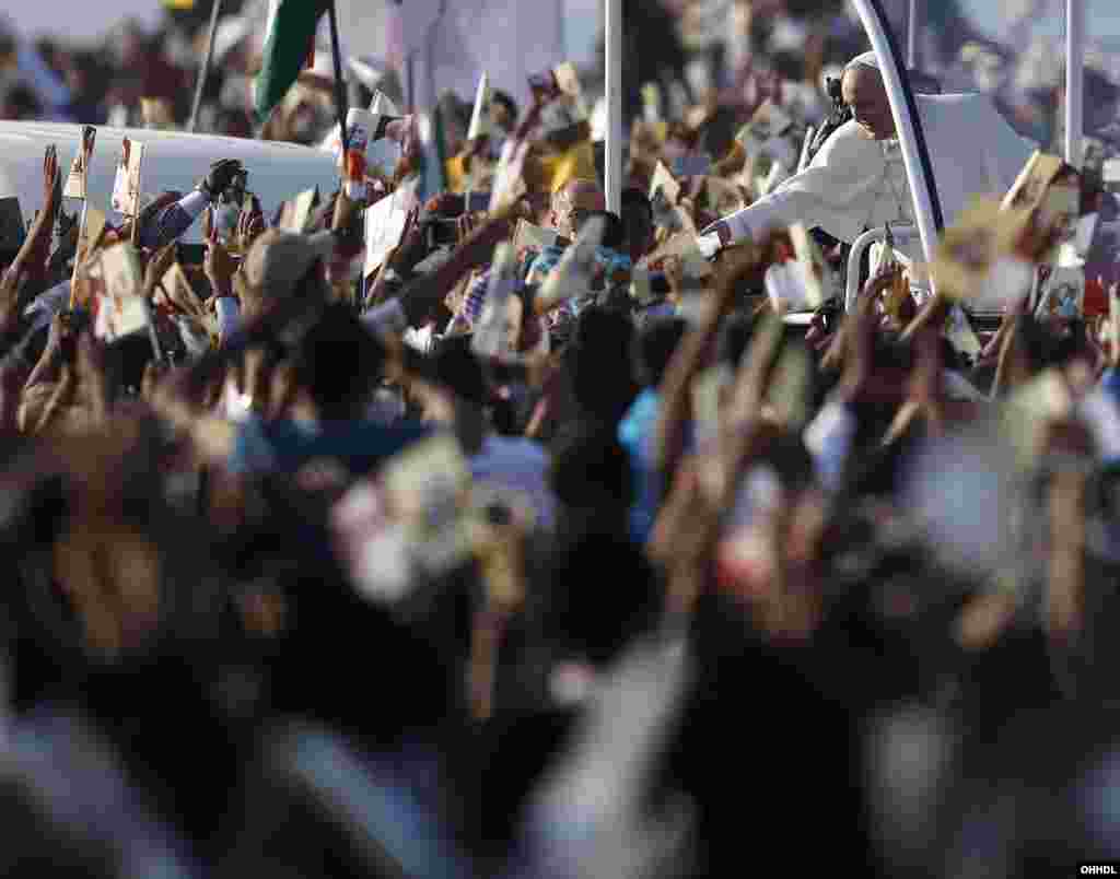 Pope Francis receives a piece of paper from a Catholic faithful as he arrives to lead mass in Colombo, Jan. 14, 2015.