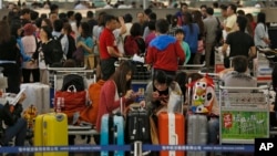 Passengers wait at airline counters at Hong Kong's international airport, Sept. 23, 2013.