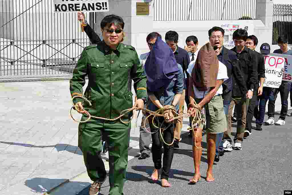 22일 미국 워싱턴 주재 중국대사관 앞에서 중국 정부의 탈북자 강제북송 중단을 촉구하는 시위가 열린 가운데, 중국 공안이 탈북자들을 체포하는 장면을 연출한 퍼포먼스.