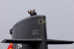FILE - Taiwan President Tsai Ing-wen waves as she boards Hai Lung-class submarine (SS-794) during her visit to a navy base in Kaohsiung, Taiwan, March 21, 2017.