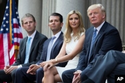FILE - From left, Eric Trump, Donald Trump Jr. and Ivanka Trump — shown with their father at a groundbreaking ceremony for the Trump International Hotel in Washington, July 23, 2014.