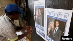 A South African man sells newspapers.