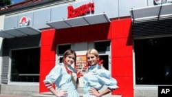 Wendy's Russia workers pose out side of the new restaurant in Moscow, August 2011