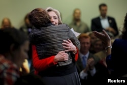 U.S. Democratic presidential candidate Hillary Clinton hugs Clai Lasher-Sommers, a survivor of domestic abuse and gun violence, at a campaign town hall meeting in Keene, New Hampshire, Oct. 16, 2015.