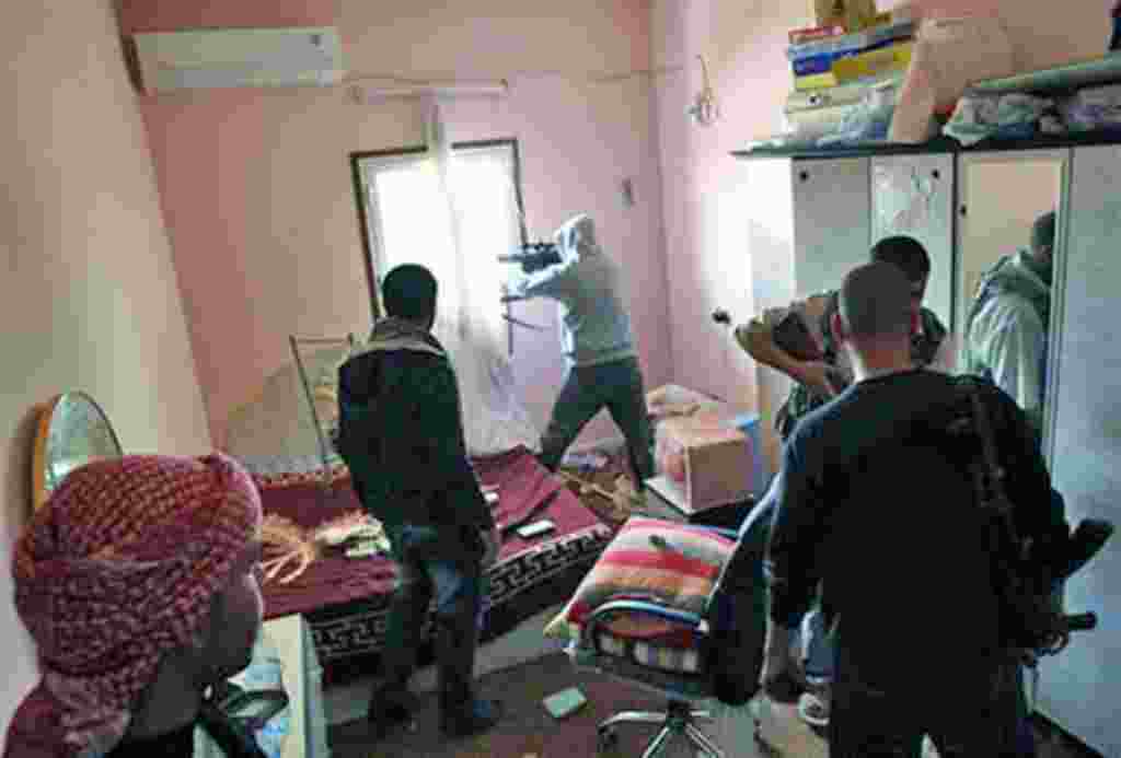 Combatientes libios rebeldes peleando desde la sala de una casa, en la ciudad de Misrata.