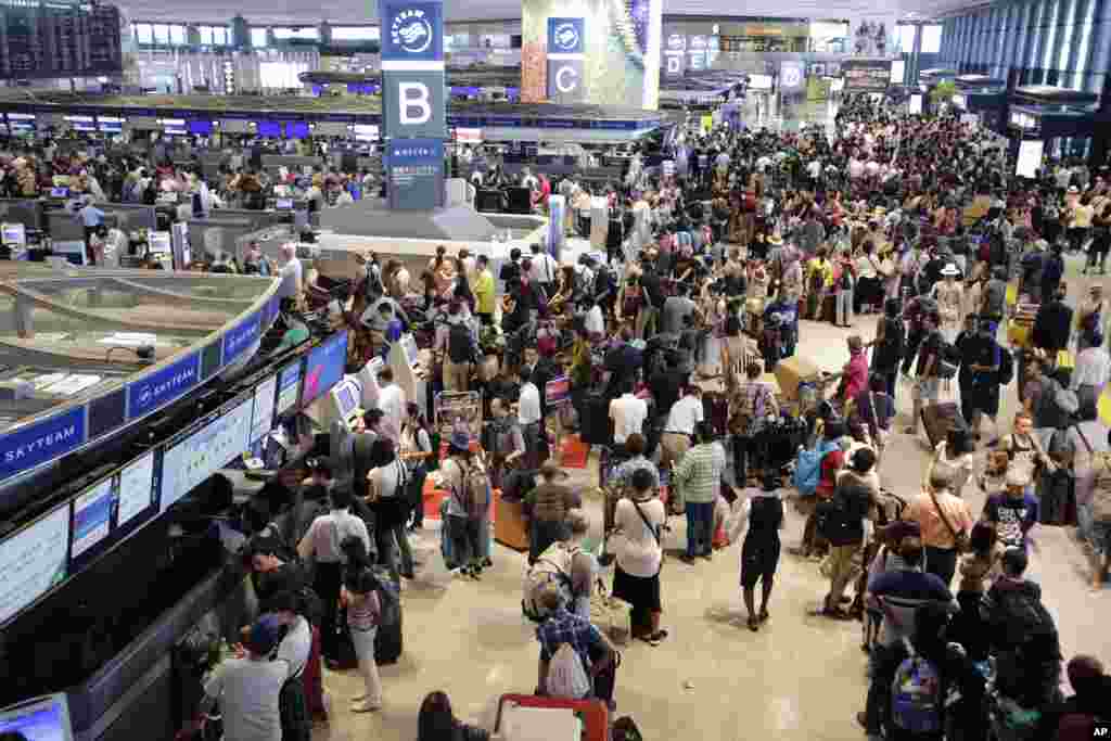 Passengers line up at the Delta Airlines check-in counter at Narita International Airport in Narita, east of Tokyo, Japan. More than 1,000 people spent the night at the airport because of a computer shutdown that halted Delta flights worldwide.