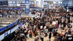 Passengers line up at the Delta Air Lines check-in counter at Narita international airport in Narita, east of Tokyo, Aug. 9, 2016. 