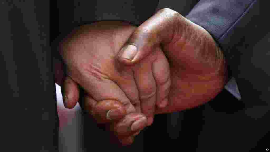 The hand of Chinese President Xi Jinping, left, holds the hand of Zimbabwean President Robert Mugabe, upon his arrival in Harare, Zimbabwe, Tuesday, Dec. 1. 2015. Jinping is in Zimbabwe for a two day State visit during which he is set to sign some bilateral agreements aimed at strengthening relationships between the two countries. 