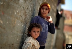 FILE - Two Palestinian refugee children lean on the wall of a house in Gezirat al-Fadel village, Sharqiya, about 150 kilometers east of Cairo, Egypt, May 17, 2013.