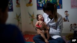 Seorang ibu yang bayinya menderita microcephaly di Brazil (foto: ilustrasi). 