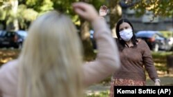 Women exercise during a therapy session in a park in Sarajevo, Bosnia Monday, Oct. 26, 2020. (AP Photo/Kemal Softic)