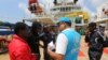 Un migrant africain s'entretient avec un responsable du Haut Commissariat des Nations Unies pour les réfugiés (HCR) à bord du navire "Sarost 5" amarré dans le port de Zarzis, dans le sud de la Tunisie, le 1er août 2018.