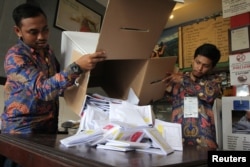 Petugas KPPS menghitung surat suara di sebuah TPS di Surabaya, Jawa Timur, 17 April 2019. (Foto: Antara via Reuters)