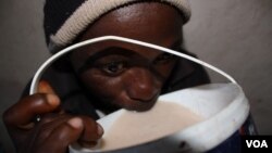 A man drinks umqombothi beer at a tavern in South Africa. (D. Taylor/VOA)