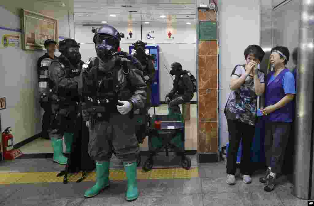 South Korean army soldiers stand as women watch during an anti-terror drill as part of the Ulchi Freedom Guardian exercise, at Yoido Subway Station in Seoul.