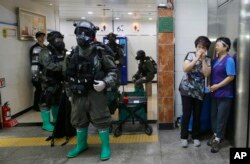 FILE - South Korean army soldiers stand as women watch during an anti-terror drill as part of the Ulchi-Freedom Guardian exercise, at Yoido Subway Station in Seoul, South Korea, Aug. 23, 2016.