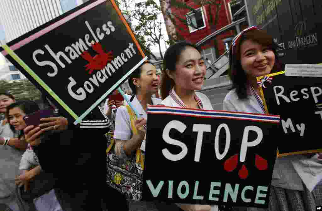 Medical workers display placards in support of an anti-government march in Bangkok, Jan. 20, 2014. 