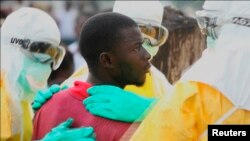 Health workers surround an Ebola patient who escaped from quarantine from Monrovia's Elwa hospital, in the center of Paynesville in this still image taken from a Sept. 1, 2014 video. 