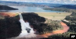 This image from video provided by the office of Assemblyman Brian Dahle shows water flowing over an emergency spillway of the Oroville Dam in Oroville, Calif., Feb. 10, 2017.