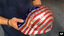 Jon Hile, of Louisville, Ky., holds a hardhat, Aug. 19, 2016, with signatures of friends he met during his time volunteering at ground zero in Manhattan after the attacks of Sept. 11, 2001.
