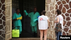 FILE - Medecins Sans Frontieres (MSF) workers talk to a worker at an isolation facility, prepared to receive suspected Ebola cases, at the Mbandaka General Hospital, in Mbandaka, Democratic Republic of Congo, May 20, 2018.