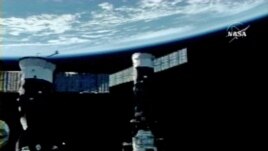 In this image from NASA Television, Earth is the background as the International Space Station is seen during a space walk by Cosmonauts Fyodor Yurchikhin and Oleg Kotov