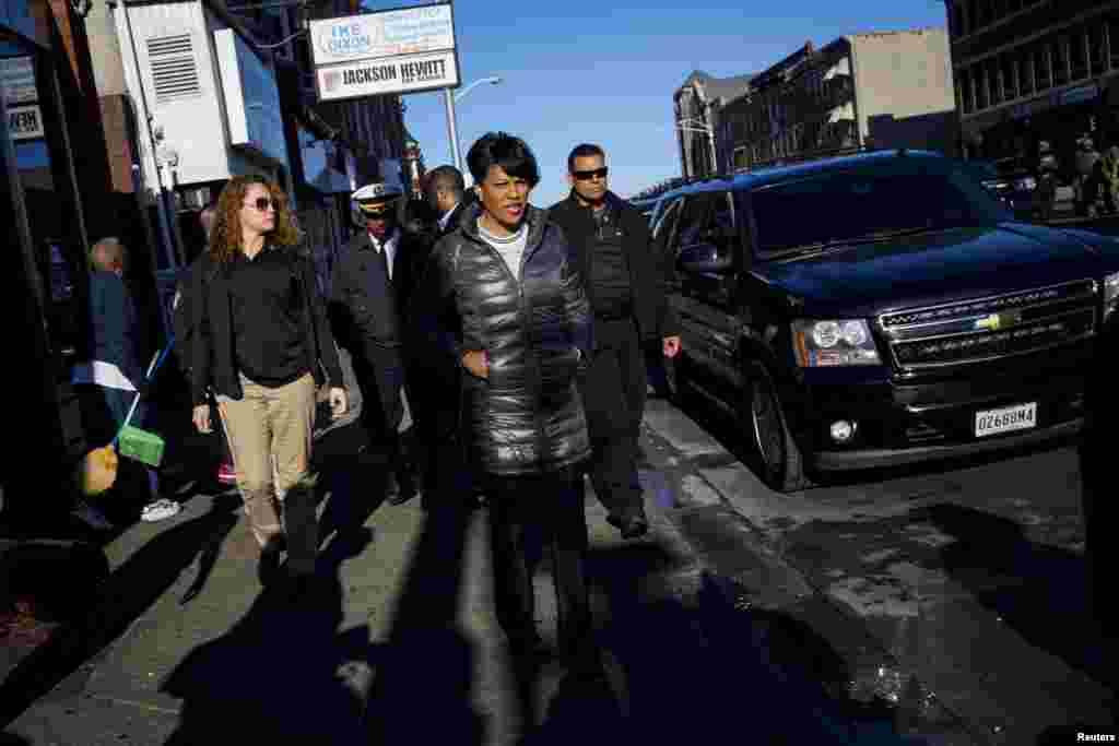 A prefeita de Baltimore Stephanie Rawlings-Black passa pela Avenida Pennsylvania enquanto a polícia do estado de Maryland fica em guarda.