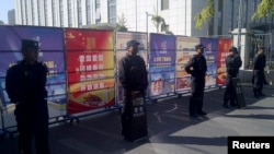 Policemen in riot gear guard at checkpoint on road near a courthouse where ethnic Uighur academic Ilham Tohti's trial is taking place in Urumqi, Xinjiang Uighur Autonomous Region, Sept. 17, 2014.
