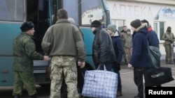 Prisoners of war (POWs) from the separatist self-proclaimed Luhansk People's Republic (LNR) board a bus during the exchange of captives near the city of Bakhmut in Donetsk region, Ukraine, Dec. 27, 2017.
