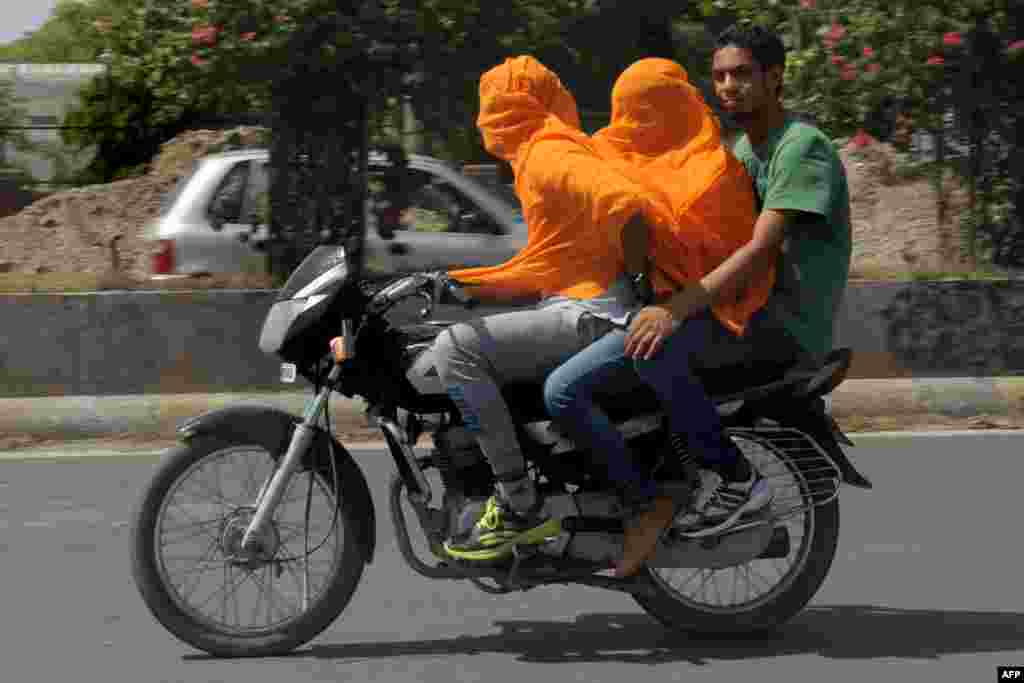 Indian motorcyclists cover their heads as they travel in the heat in Amritsar. Amritsar and Ludhiana in Punjab and Hisar and Bhiwani in Haryana have been reeling under severe heat conditions with temperatures hovering between 45-47&deg;C (113-116&deg;F).