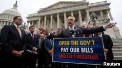 Pemimpin mayoritas dalam Senat AS, Senator Harry Reid (kanan) memberikan penjelasan kepada media di depan gedung Capitol soal kebuntuan anggaran (9/10).