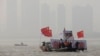 12月26日在湖北武汉，打着中国国旗、展示已故中共领导人毛泽东巨幅画像的船只引领着人们进行冬泳