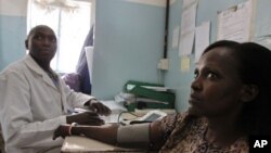 Un docteur kenyan reçoit une malade du sida dans son cabinet dans la banlieue de Kibera, à Nairobi, au Kenya, le 30 novembre 2011.