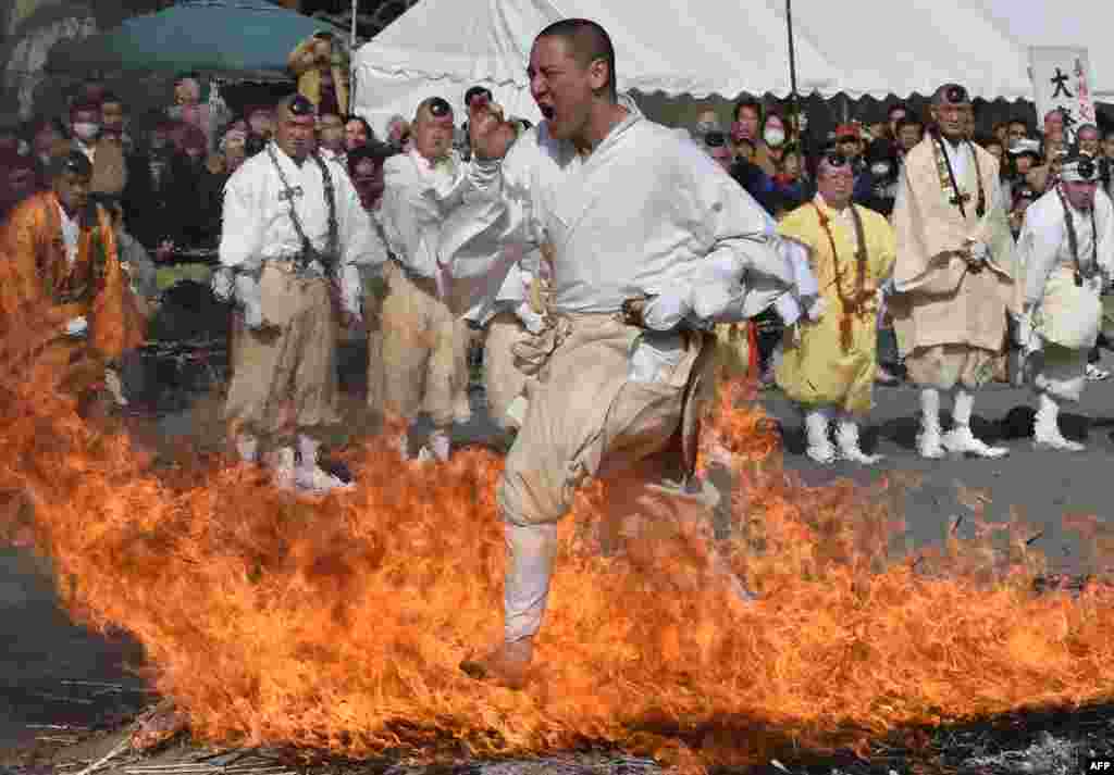 Seorang pria Buddha menginjak bara api tanpa alas kaki pada festival keagamaan &#39;Nagatoro Hi-Matsuri&#39; untuk menyambut musim semi di Kuil Fudoji, Nagatoro, Saitama, Jepang.