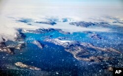 Icebergs float in a fjord after calving off from glaciers on the Greenland ice sheet in southeastern Greenland, Thursday, Aug. 3, 2017. (AP Photo/David Goldman)