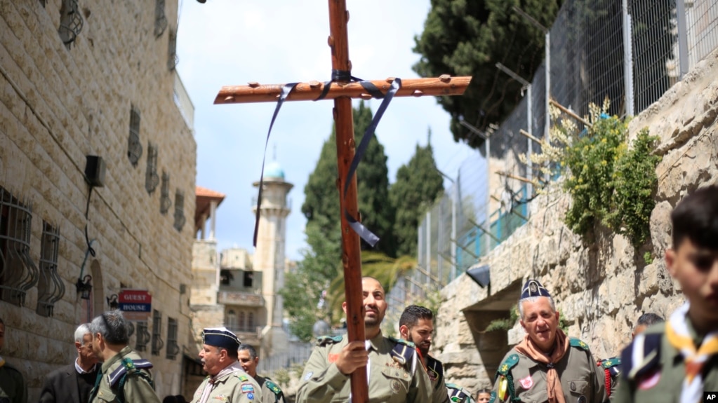 Cristianos de un movimiento de boys scouts, uno llevando una cruz, caminan por la Via Dolorosa hacia la Iglesia del Santo Sepulcro, donde segÃºn la tradiciÃ³n fue cruxificado Jesucristo durante el Viernes Santo, el viernes 19 de abril de 2019.