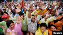 Cambodians raise their arms as they gather during a protest at Freedom Park in central Phnom Penh, Dec. 17, 2013.