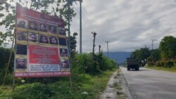 Baliho berisi Daftar Pencarian Orang (DPO) Kelompok Teroris Mujahidin Indonesia Timur (MIT) yang dipajang di sisi jalan Trans Sulawesi di Kecamatan Poso Pesisir, Poso. Jumat (11/12/2020). (Foto: VOA/Yoanes Litha)