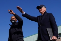 Calon presiden dari Partai Demokrat AS Joe Biden dan mantan Presiden AS Barack Obama memberi isyarat pada acara kampanye drive-in di Flint, Michigan, AS, 31 Oktober 2020. (Foto: REUTERS/Brian Snyder)